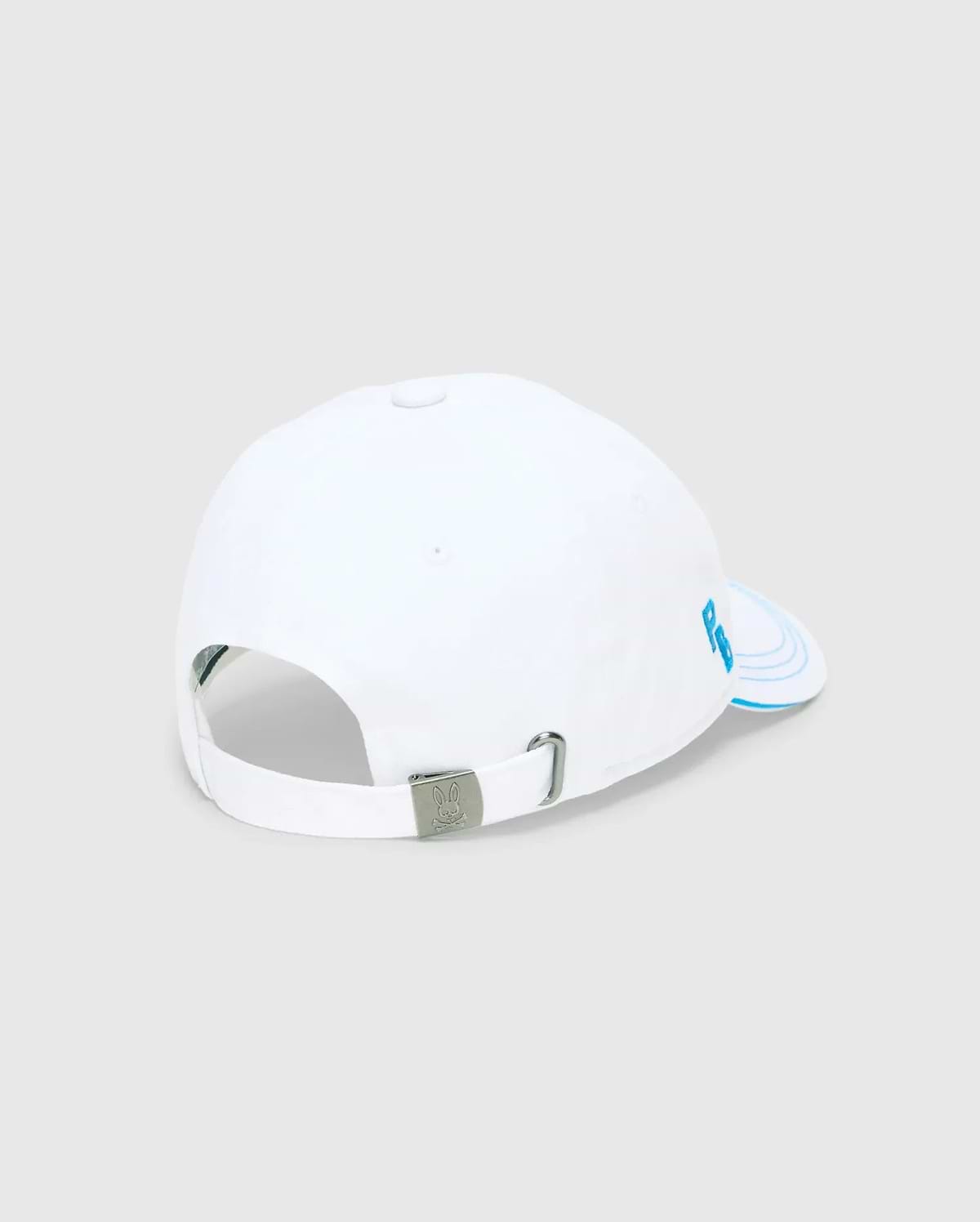 Mens Ray Baseball Cap, white smooth cotton twill with light blue embroidered PB initials on the side panel, concentric lines on the brim, and a metal buckle featuring the Psycho Bunny skull logo.