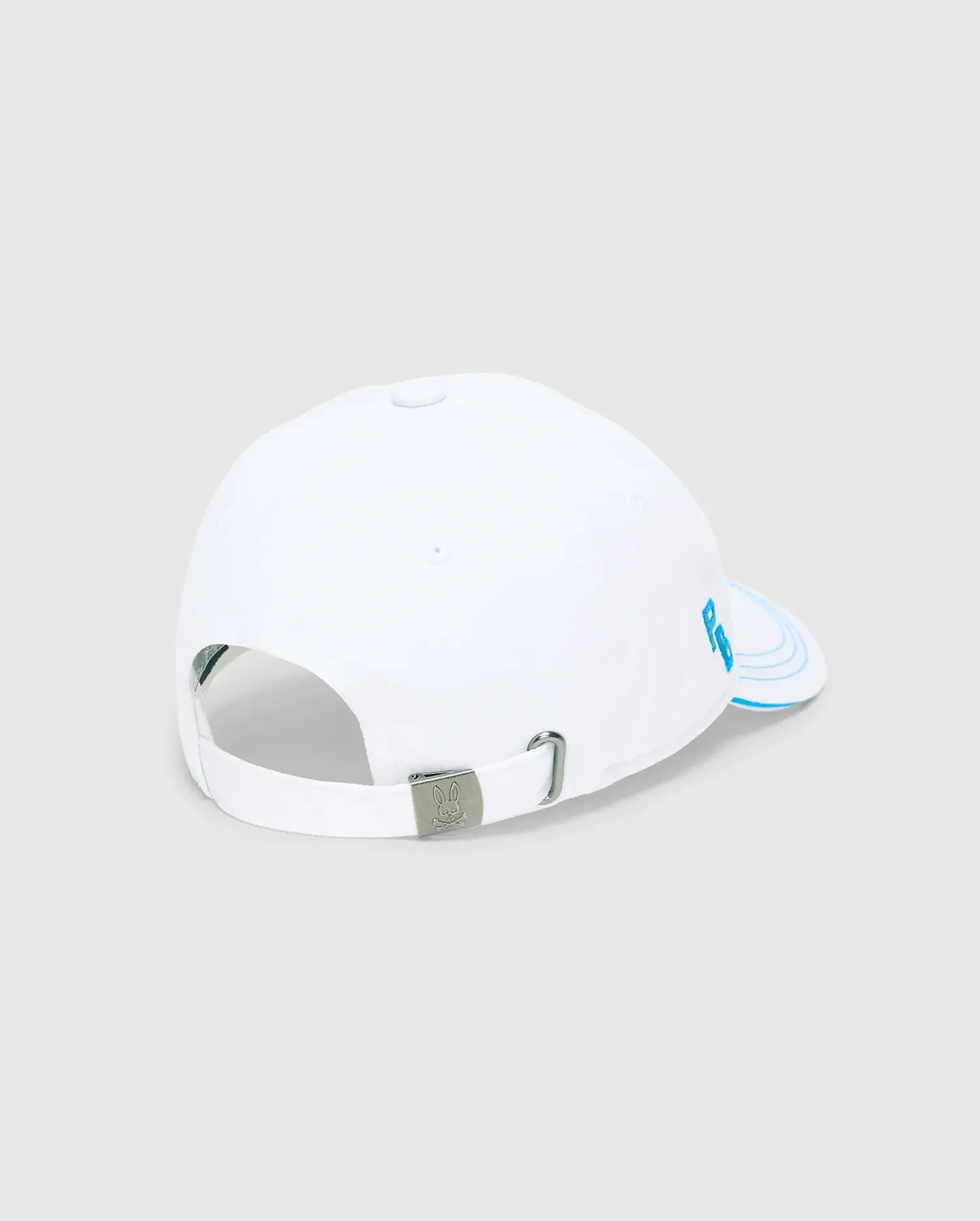 Mens Ray Baseball Cap, white smooth cotton twill with light blue embroidered PB initials on the side panel, concentric lines on the brim, and a metal buckle featuring the Psycho Bunny skull logo.