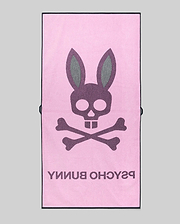 The Psycho Bunny MENS CLASSIC BUNNY TOWEL (MO1700004) is pink, showcasing a large dark gray bunny skull and crossbones with "PSYCHO BUNNY" below, all set against a plain gray background.