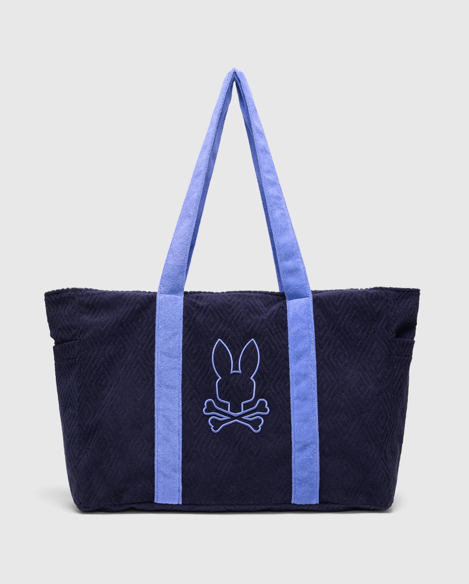 Navy Tristan Towel Tote with a subtle quilted diamond pattern, featuring periwinkle blue terry cloth straps and a large embroidered periwinkle Psycho Bunny skull logo on the front.