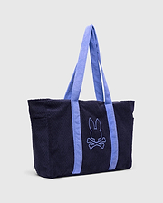 Tristan Towel Tote in navy blue terry cloth with a quilted diamond pattern, featuring light blue straps and a large, centered embroidered Psycho Bunny skull logo.