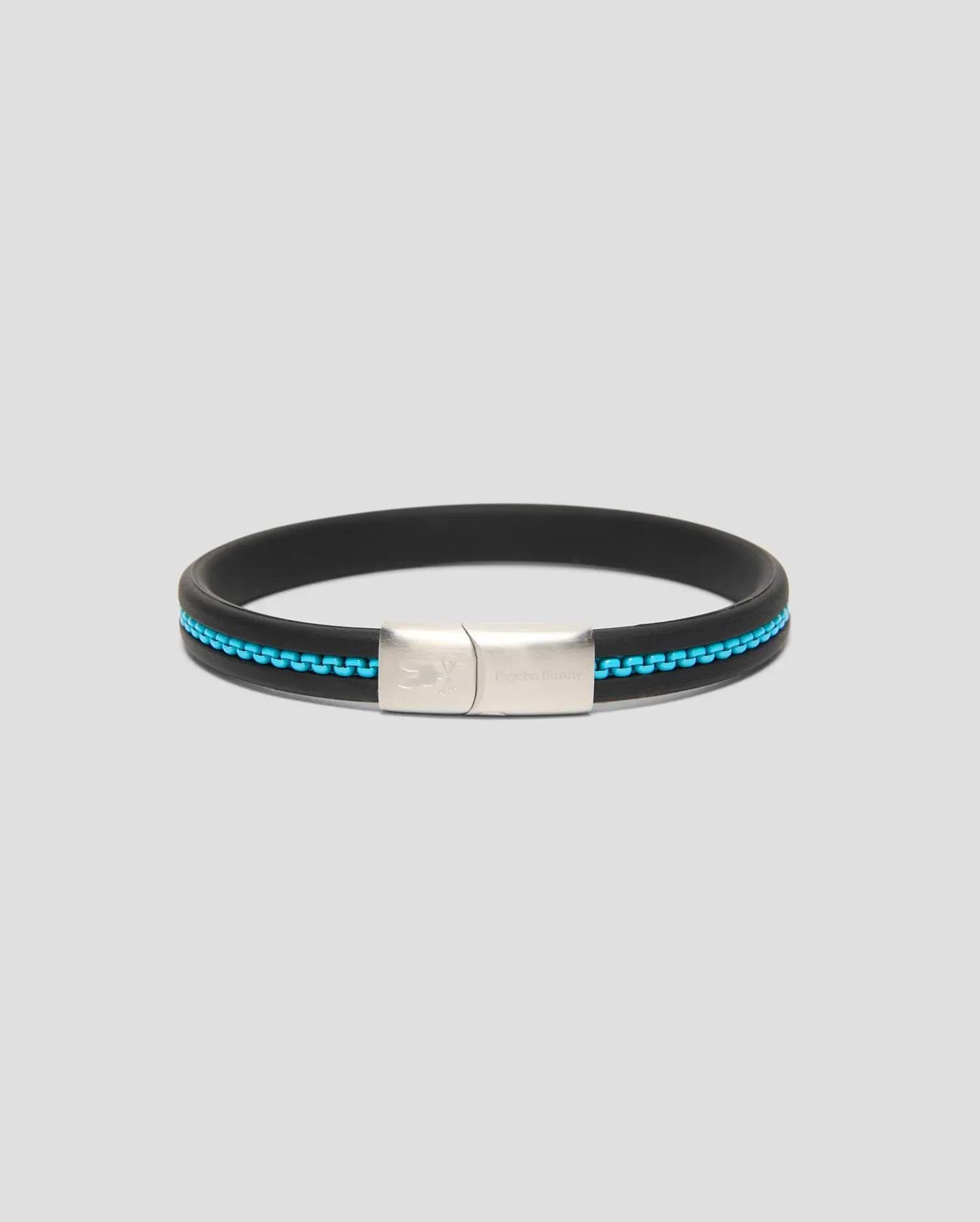 Mens Link Rubber Bracelet, a sleek black rubber band with a vibrant turquoise chain-link inlay and a polished silver clasp featuring engraved Psycho Bunny branding and skull logo. (1)