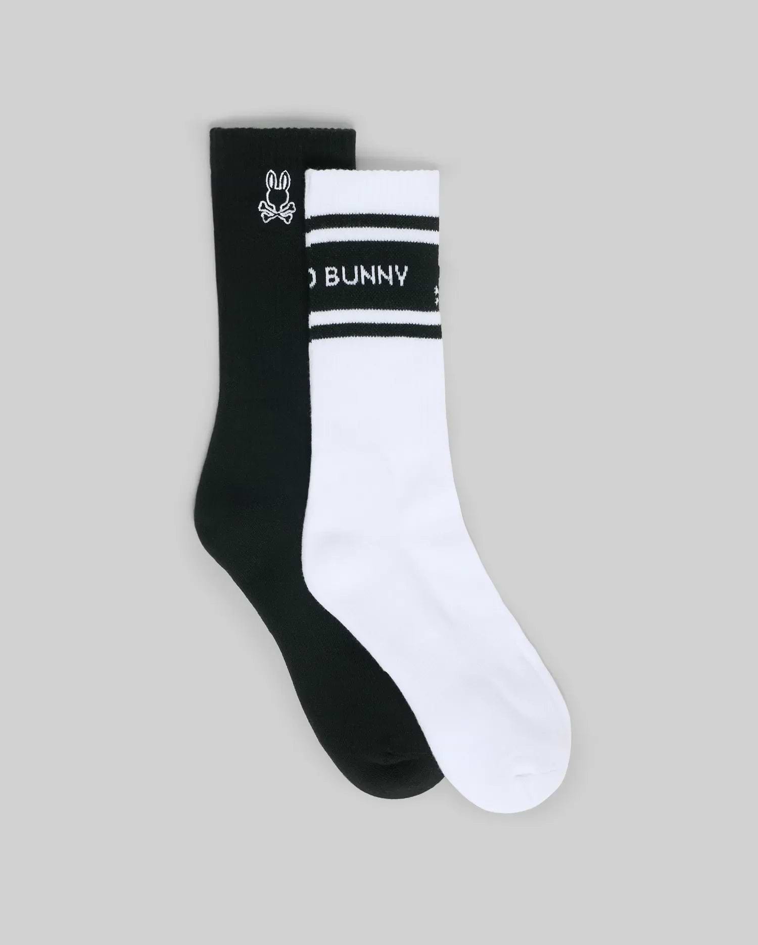 The Psycho Bunny MENS 2 PACK SPORT SOCK (MO2200037) features one black sock with a white bunny logo and one white sock with black stripes, "BUNNY" text, and a bunny logo, shown on a plain grey background.