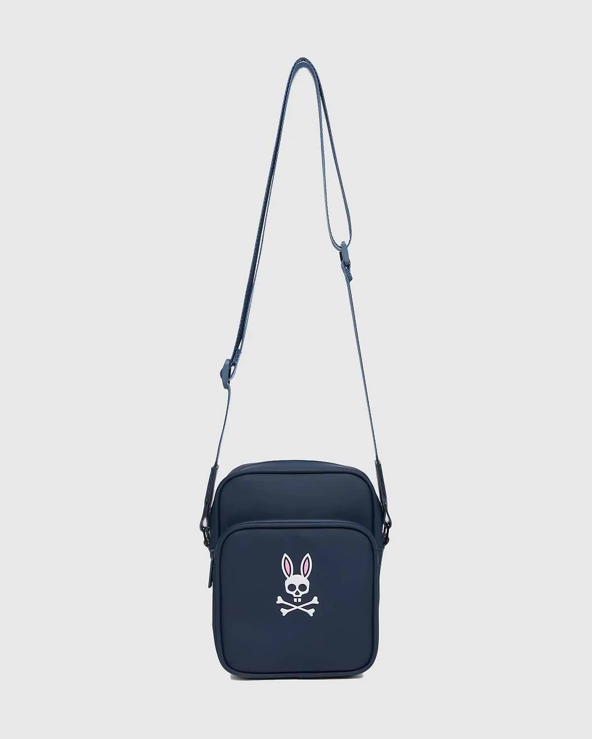 Classic Bunny Messenger Bag in navy blue, featuring a prominent white and pink Psycho Bunny skull logo on the front pocket, made from smooth, durable fabric.