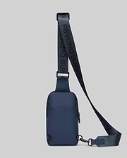 Mens Rubberized Crossbody in deep navy blue with black accents, featuring a smooth rubberized texture and a prominent woven strap displaying repeating Psycho Bunny branding. (3)