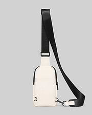Mens Rubberized Crossbody in cream with black trim and a front zipper. Features a rubberized texture and an adjustable black woven strap with repeating Psycho Bunny text branding.