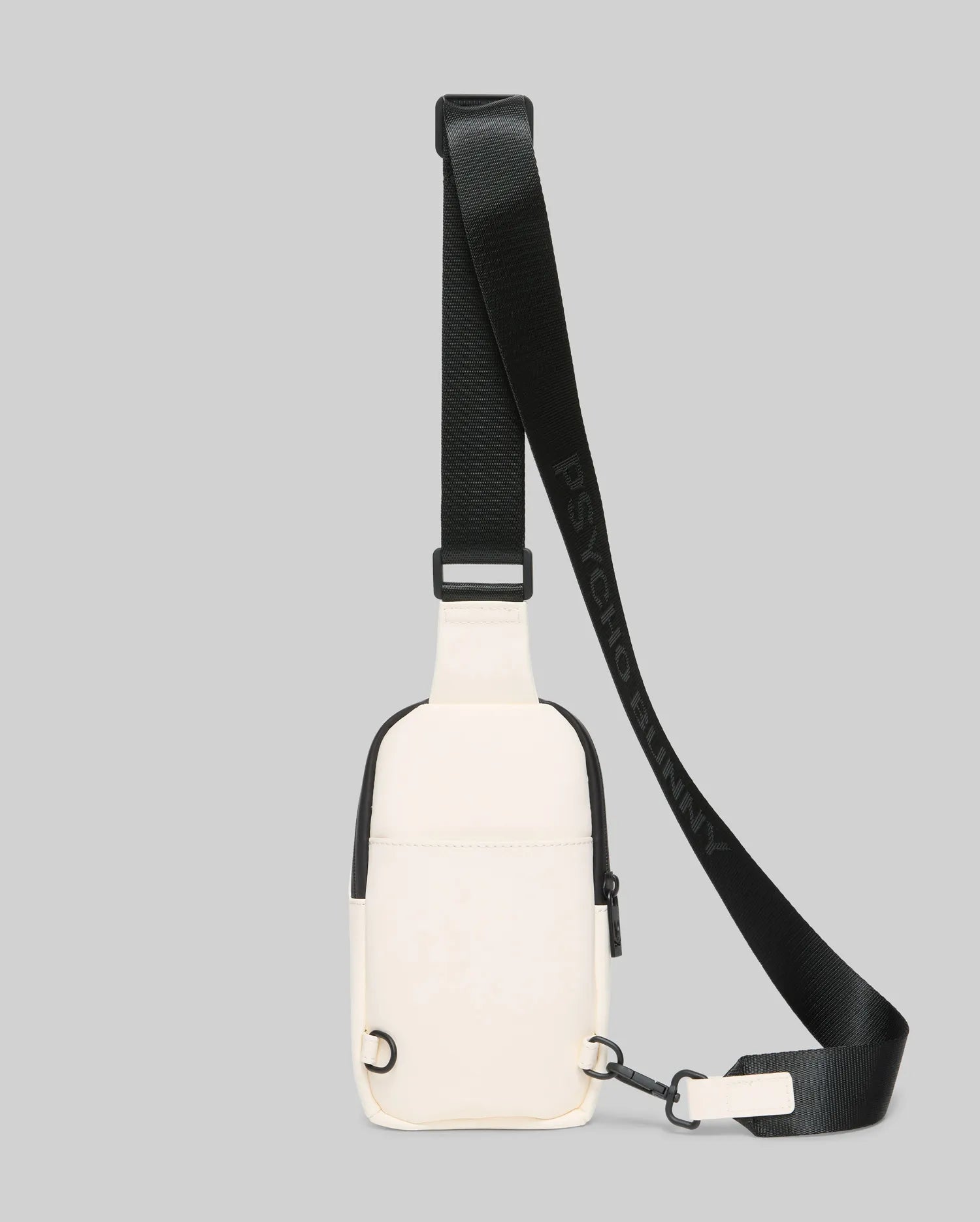 Mens Rubberized Crossbody in cream with black trim and a front zipper. Features a rubberized texture and an adjustable black woven strap with repeating Psycho Bunny text branding.
