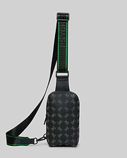 Mens Rubberized Crossbody in black with an all-over grey Psycho Bunny skull logo pattern and a black and green branded woven strap featuring the Psycho Bunny text. (1)