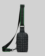Mens Rubberized Crossbody in black with an all-over grey Psycho Bunny skull logo pattern and a black and green branded woven strap featuring the Psycho Bunny text. (1)