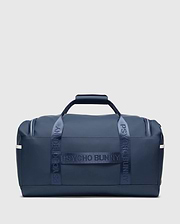 Classic Bunny Gym Bag in navy blue, featuring smooth matte material, white side stripes, and prominent Psycho Bunny text branding on the woven carry straps.