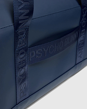 Sleek navy Classic Bunny Gym Bag with a smooth, matte texture and woven straps featuring repeated tonal Psycho Bunny logo text.