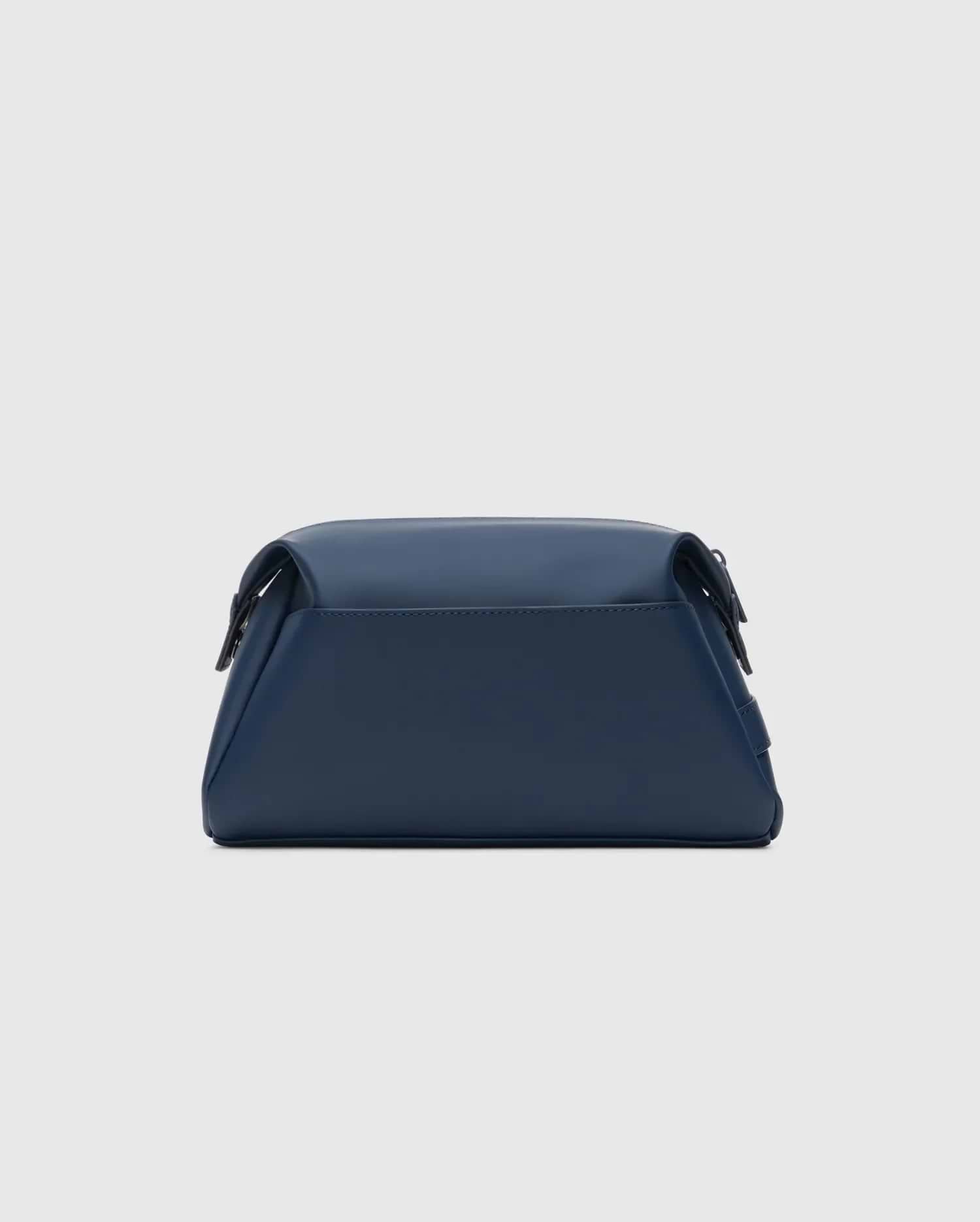 Classic Bunny Toiletry Kit, a sleek navy blue travel pouch crafted from smooth, matte faux leather, featuring a structured rectangular design with soft edges and subtle dark hardware.
