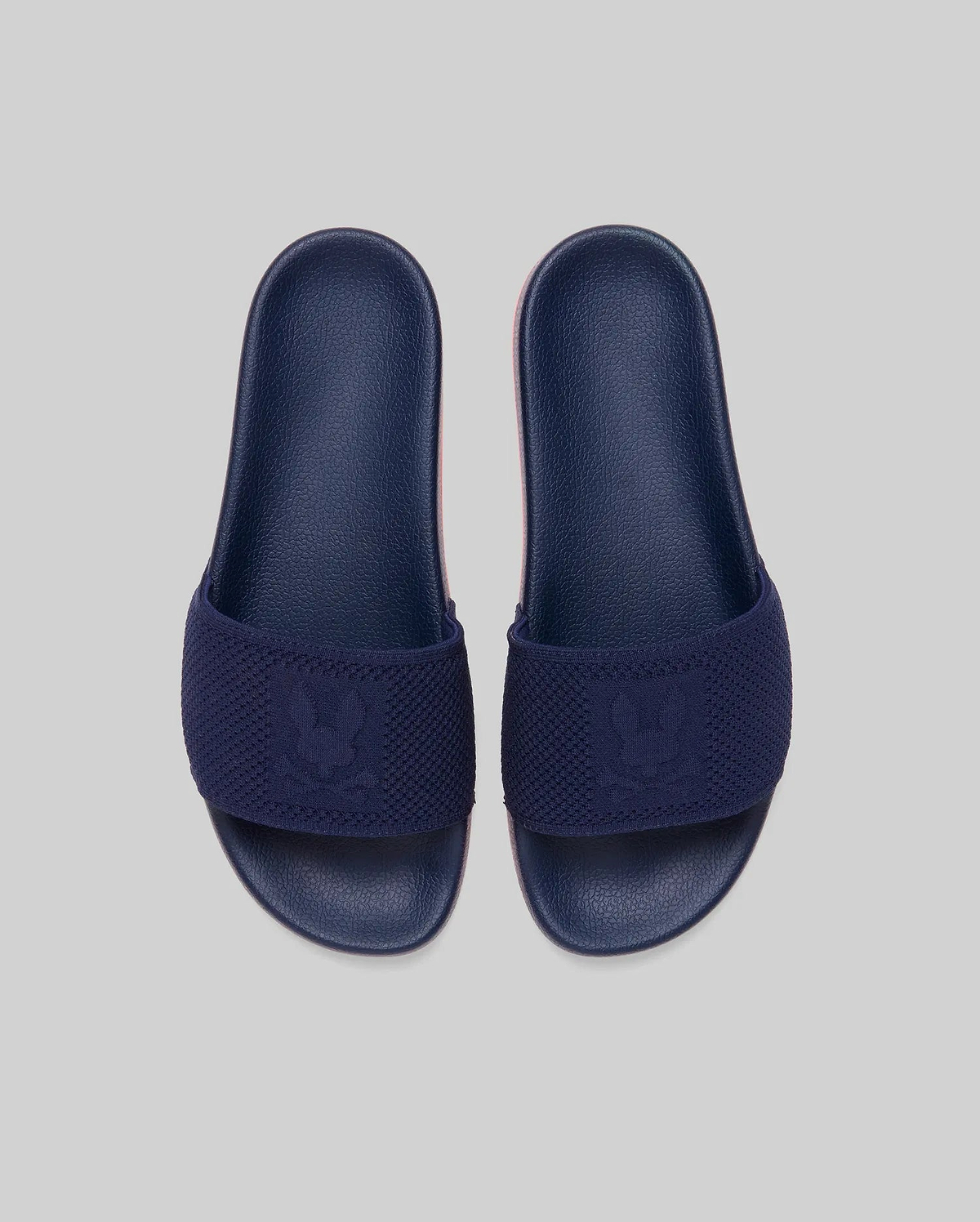 Mens Contrast Sole Knit Slides in navy with a subtle pink contrast sole, featuring a knitted strap with a woven Psycho Bunny skull logo. (3)