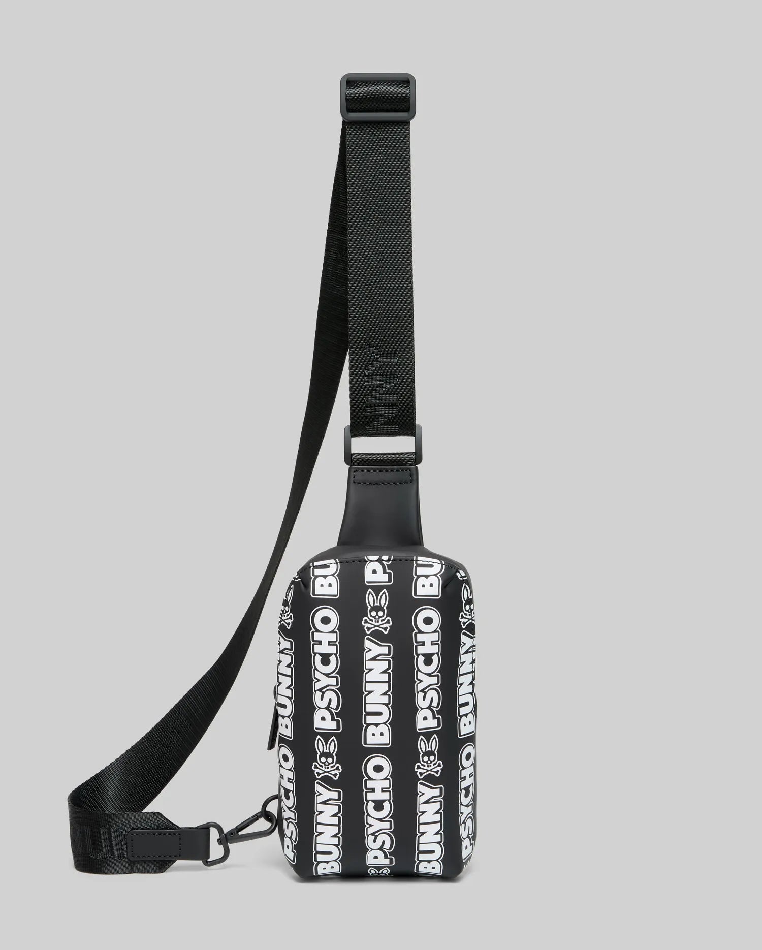Mens Rubberized Crossbody bag featuring an all-over white repeating Psycho Bunny text and skull logo pattern on a black rubberized body with a black woven adjustable strap.
