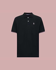 The Psycho Bunny MENS ARCHIVE CLASSIC BUNNY PIQUE POLO (MT0100010) is a black Pima cotton short-sleeve polo with a collar, two buttons, white and pink trim accents, and a white embroidered logo on the chest. Displayed on light pink.