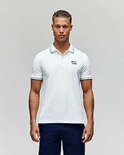 A man faces forward in dark pants and a Psycho Bunny MENS ARCHIVE NEON BUNNY POLO MT0100018—a regular fit white, 100% Pima cotton short-sleeve shirt featuring a small embroidered Bunny on the chest—against a plain light background. (4)