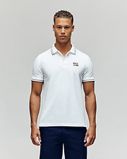 A man faces forward in dark pants and a Psycho Bunny MENS ARCHIVE NEON BUNNY POLO MT0100018—a regular fit white, 100% Pima cotton short-sleeve shirt featuring a small embroidered Bunny on the chest—against a plain light background. (4)