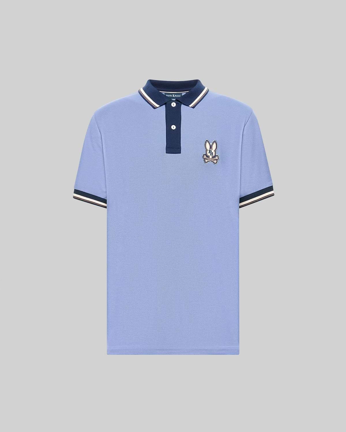 The Psycho Bunny MENS WADE PIQUE POLO (MT0100044) features light blue Pima cotton, a navy collar, white buttons, signature bunny patch on the chest, and navy & white colorblock tipped cuffs. Shown on a plain gray background. (5)