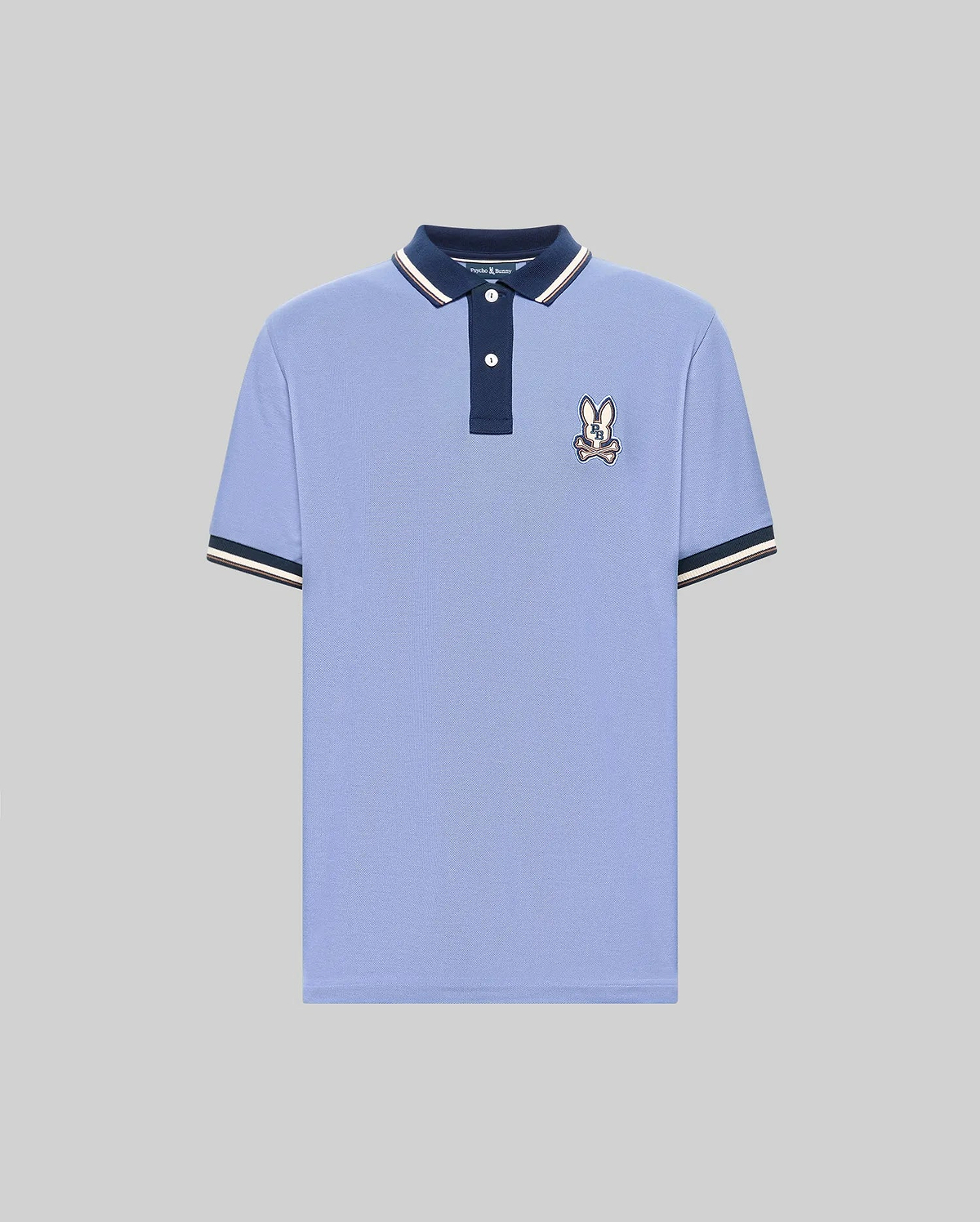 The Psycho Bunny MENS WADE PIQUE POLO (MT0100044) features light blue Pima cotton, a navy collar, white buttons, signature bunny patch on the chest, and navy & white colorblock tipped cuffs. Shown on a plain gray background. (5)