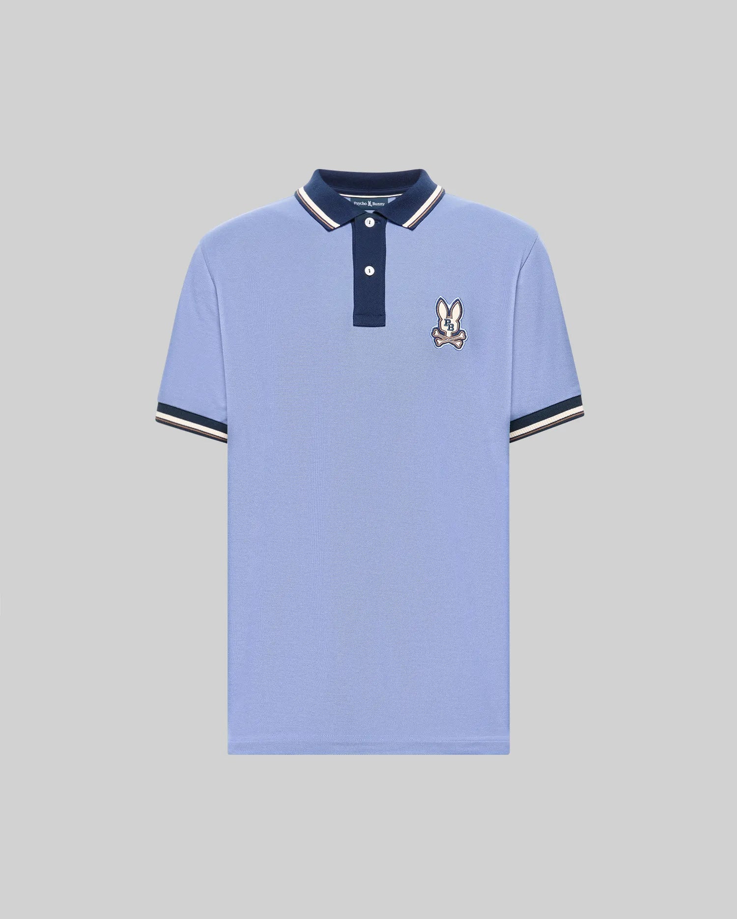 The Psycho Bunny MENS WADE PIQUE POLO (MT0100044) features light blue Pima cotton, a navy collar, white buttons, signature bunny patch on the chest, and navy & white colorblock tipped cuffs. Shown on a plain gray background. (5)