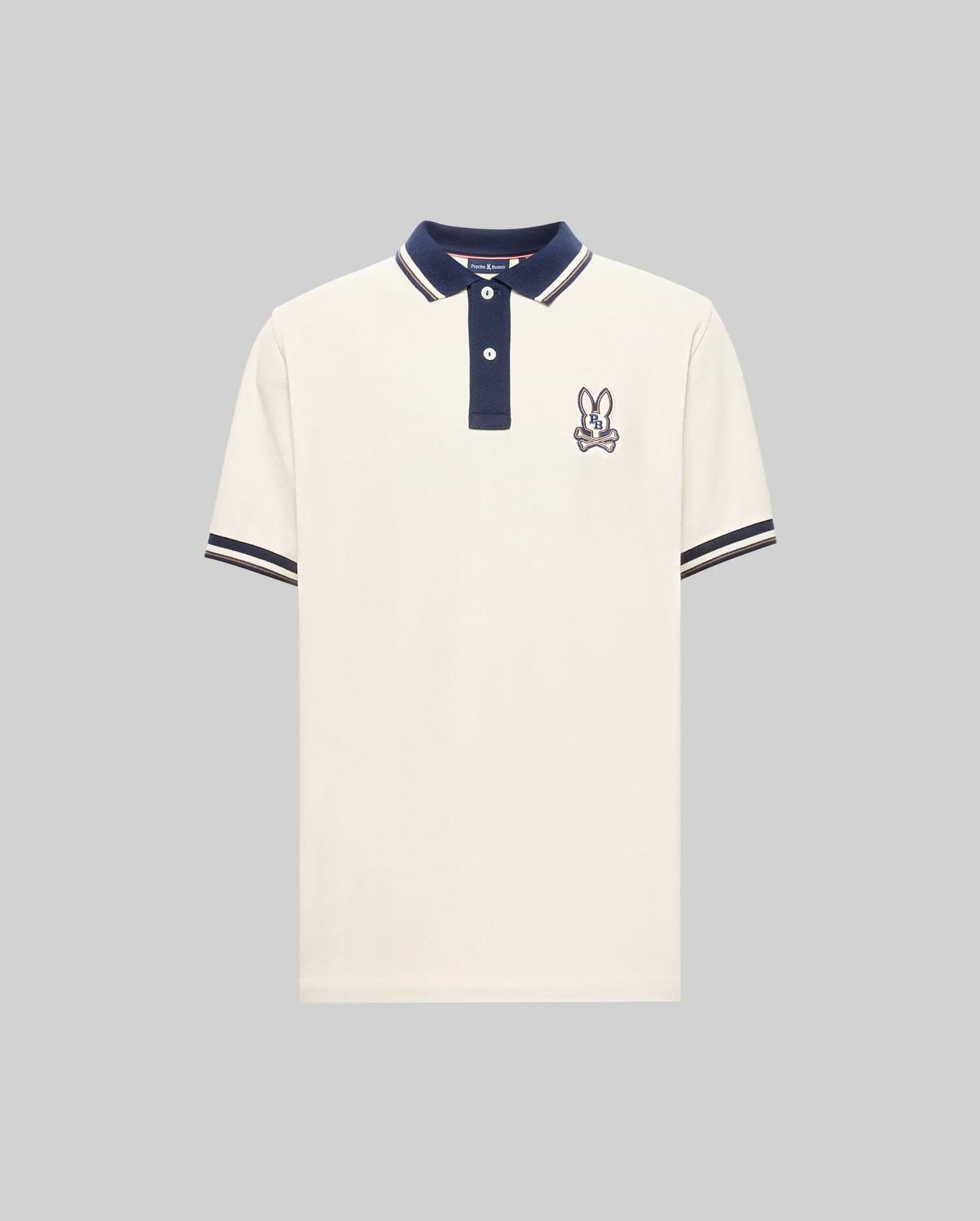 The Psycho Bunny MENS WADE PIQUE POLO (MT0100044) is a white colorblock polo with navy blue collar and sleeve cuffs, plus an embroidered bunny patch on the left chest.