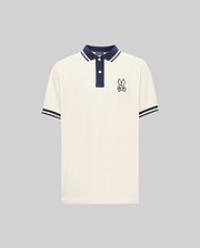 The Psycho Bunny MENS WADE PIQUE POLO (MT0100044) is a white colorblock polo with navy blue collar and sleeve cuffs, plus an embroidered bunny patch on the left chest.