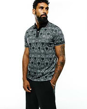 Mens Reeves All Over Bunny Sport Polo, a black and white all-over bunny skull pattern polo shirt with a classic fit, smooth performance fabric, black collar, and white striped cuffs.