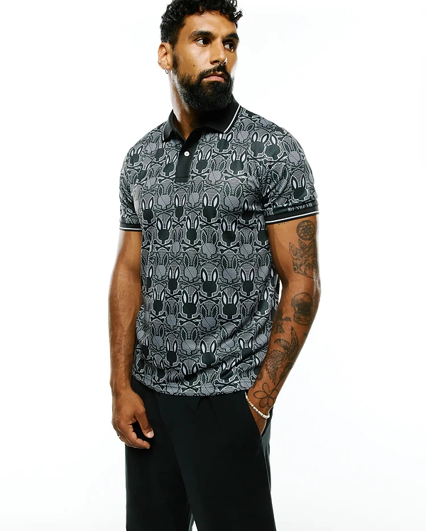 Mens Reeves All Over Bunny Sport Polo, a black and white all-over bunny skull pattern polo shirt with a classic fit, smooth performance fabric, black collar, and white striped cuffs.