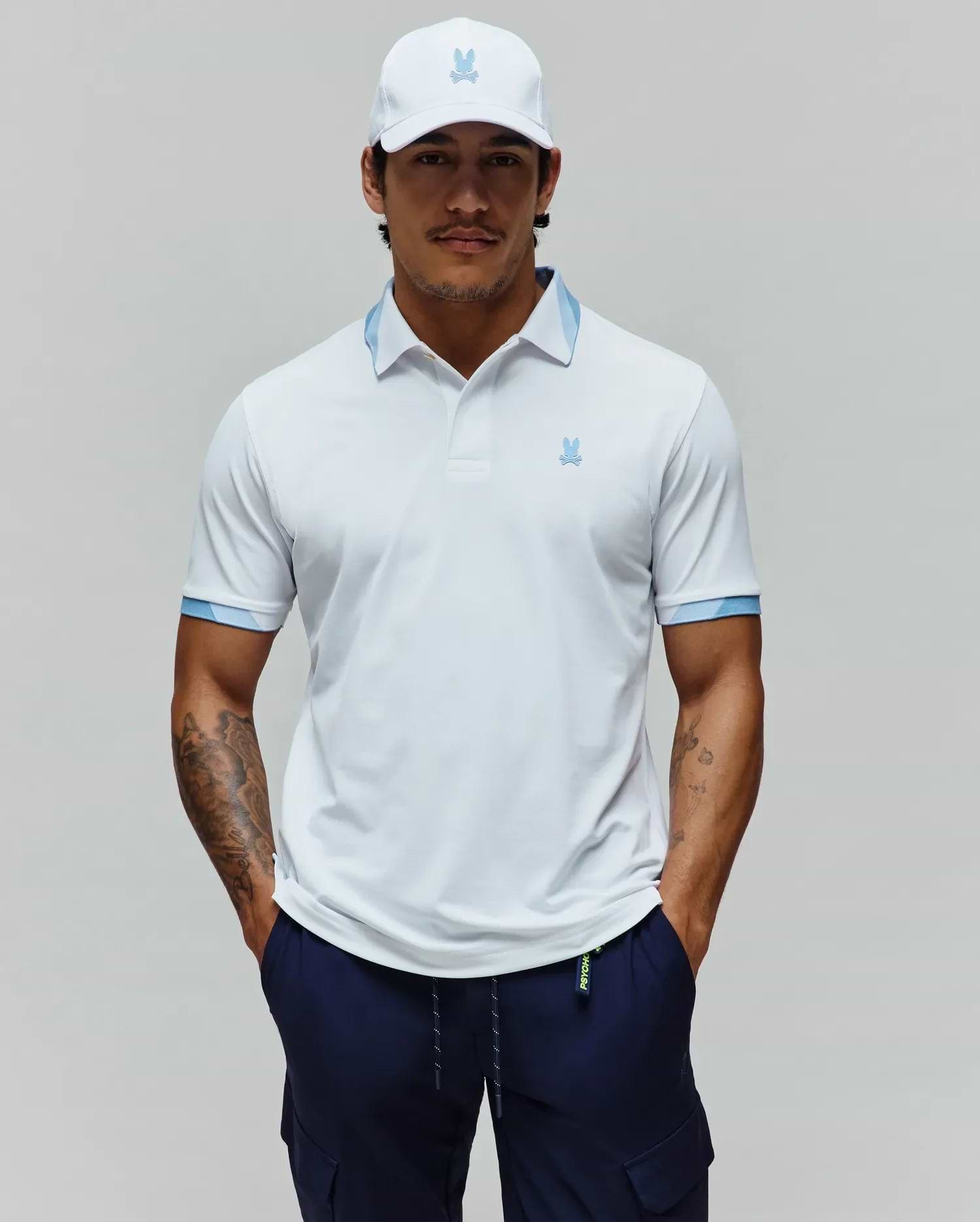 Mens Onyx Sport Polo, a white performance polo with a classic fit, features a light blue striped collar and cuffs, and a small embroidered light blue Psycho Bunny skull logo on the left chest. (1)