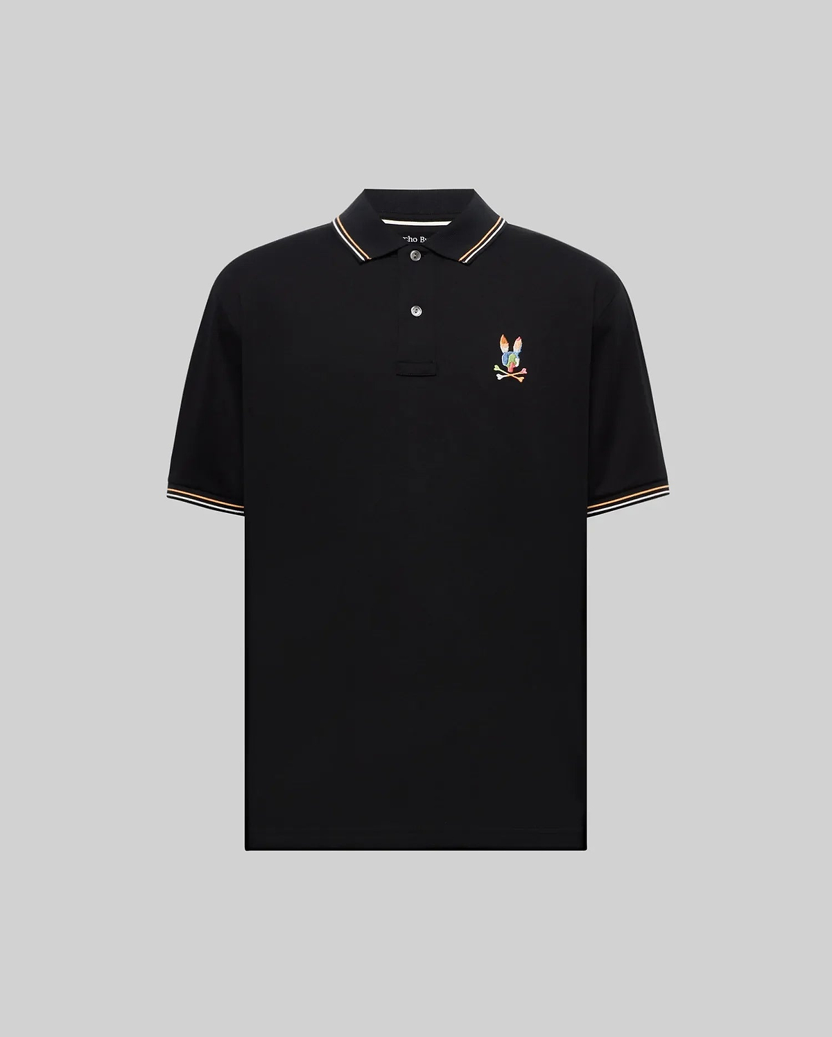 Mens Ara Pique Polo, black classic fit with white and orange striped ribbed collar and cuffs, featuring a vibrant embroidered multicolored Psycho Bunny skull and crossbones logo on the left chest.