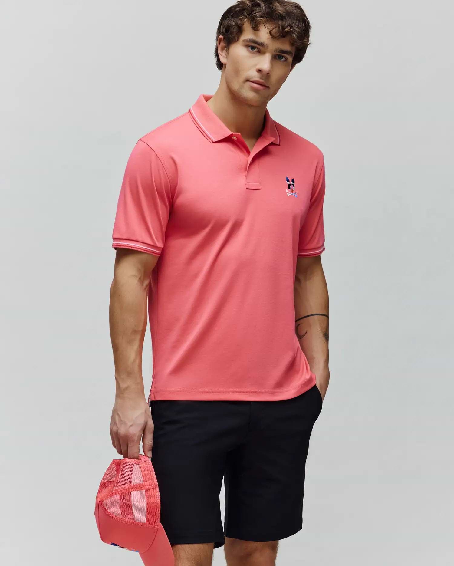 Mens Ara Pique Polo, a coral classic fit pique polo with white tipped collar and cuffs, featuring an embroidered multi-color Psycho Bunny skull logo on the left chest. (3)