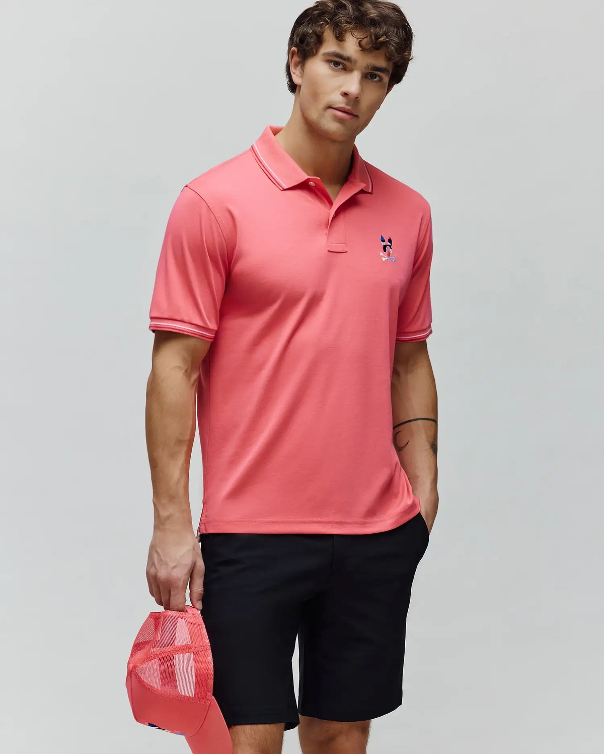 Mens Ara Pique Polo, a coral classic fit pique polo with white tipped collar and cuffs, featuring an embroidered multi-color Psycho Bunny skull logo on the left chest. (3)