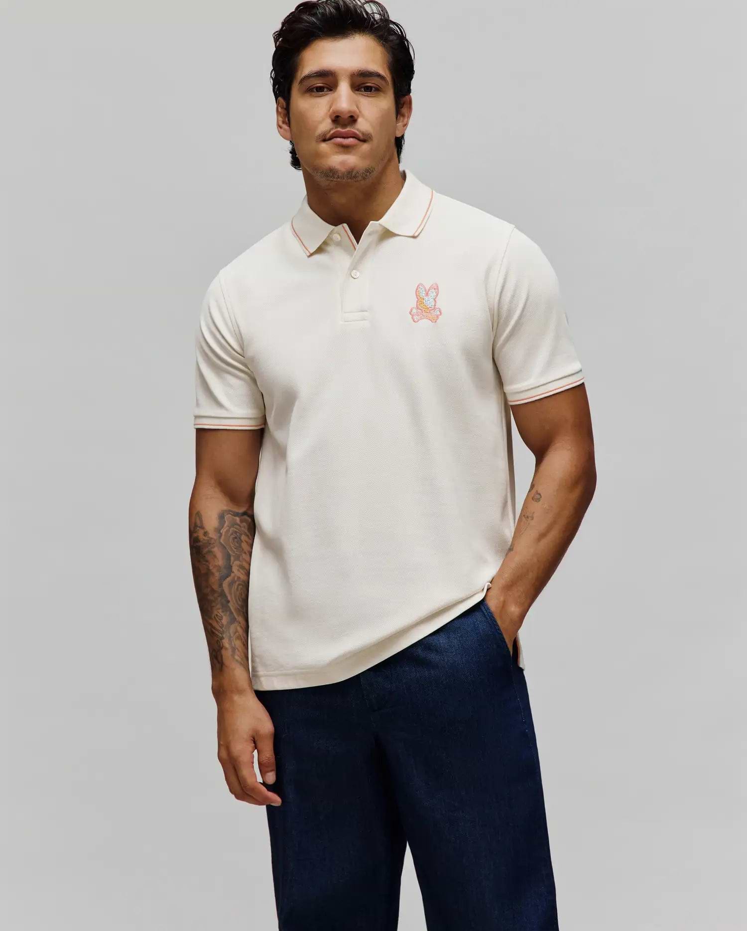 Mens Olivier Pique Polo in cream, featuring a classic fit, pique texture, orange tipping on the collar and cuffs, and an embroidered multi-color Psycho Bunny skull logo on the left chest. (3)