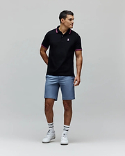Black Mens Clark Pique Polo with classic fit, pique texture, featuring a small embroidered pink Psycho Bunny skull logo on the left chest, and pink striped collar and cuffs.