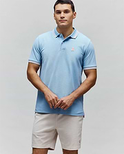 Mens Clark Pique Polo, a light blue classic fit pique polo with white and red striped collar and cuffs, featuring a small embroidered pink Psycho Bunny logo on the left chest. (3)