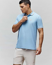 Mens Clark Pique Polo, sky blue classic fit pique knit with white and red striped collar and cuffs, featuring a small embroidered coral Psycho Bunny skull logo on the left chest and striped side vents. (1)