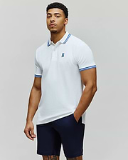 Mens Clark Pique Polo white classic fit pique polo with blue double-striped collar and cuffs, featuring a small embroidered blue Psycho Bunny skull logo on the left chest. (1)