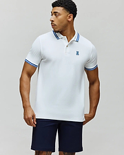 Mens Clark Pique Polo, a classic fit white pique polo with blue tipped collar and cuffs, featuring a small embroidered blue Psycho Bunny skull logo on the left chest. (3)