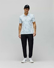 Mens Nev Sport Polo, white pique knit with an all-over light blue Psycho Bunny skull print, classic fit, featuring a small embroidered bunny logo on the left chest and ribbed collar/cuffs.