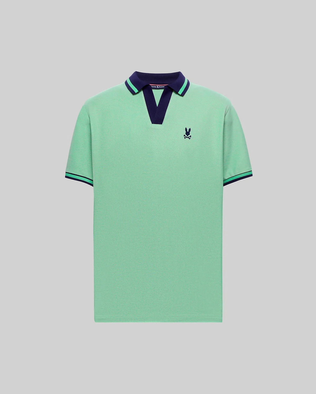 Mens Christiano Pique Polo in mint green pique with a navy V-neck collar featuring a green stripe, matching striped ribbed cuffs, and a small embroidered navy Psycho Bunny skull logo on the left chest. (4)