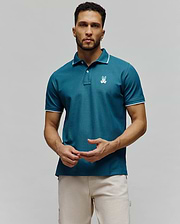 Mens Aram Pique Polo, a teal pique knit polo with white tipping on the collar and cuffs, featuring an embroidered white Psycho Bunny skull logo on the left chest in a classic fit. (4)