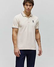 Mens Aram Pique Polo in cream, featuring a classic fit, textured pique fabric, navy blue tipping on the collar and sleeve cuffs, and a small embroidered Psycho Bunny skull logo on the left chest. (3)