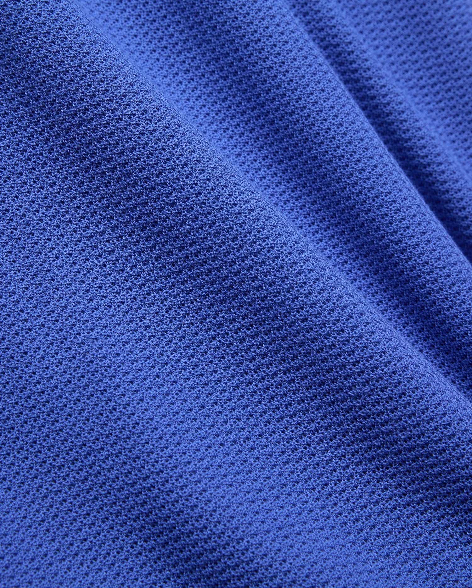Mens Innis Polo crafted from premium, vibrant royal blue pique knit fabric, featuring a distinct, breathable texture and subtle, luxurious drape, reflecting Psycho Bunny's refined streetwear aesthetic. (6)