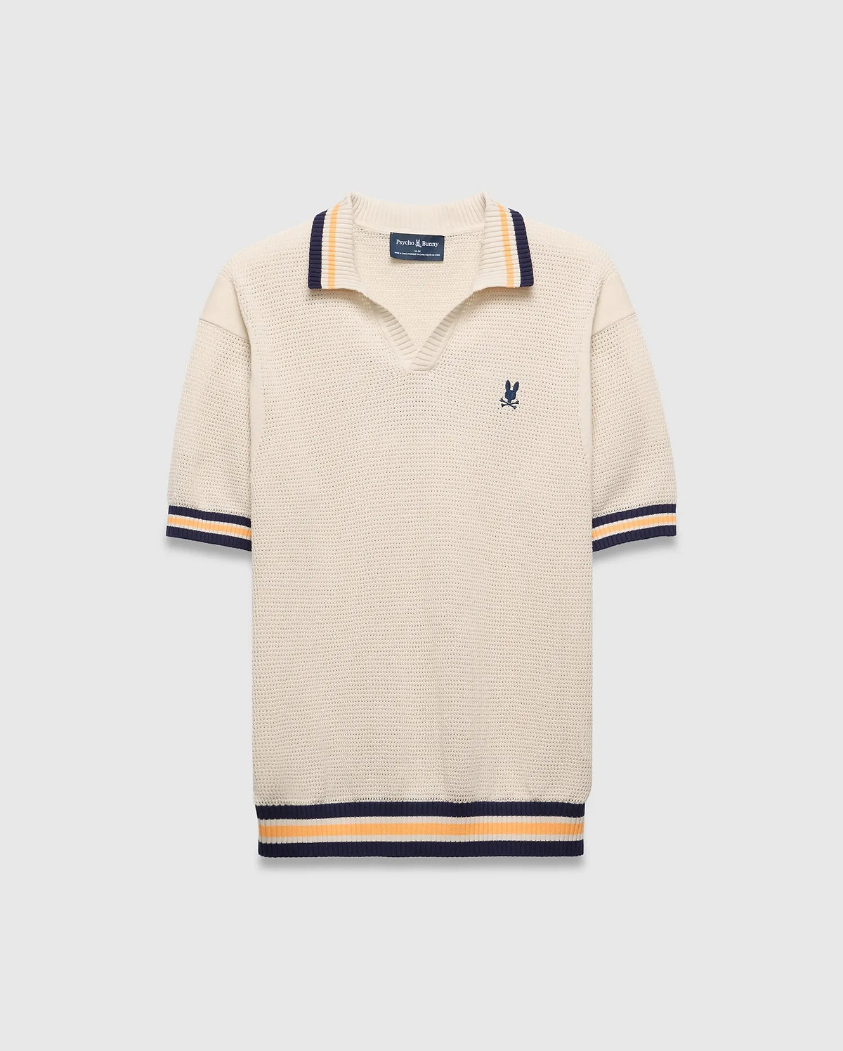 Mens Theros Knit Polo, cream textured knit with a relaxed fit, featuring a V-neck, navy and orange striped ribbed collar, cuffs, and hem, and a small embroidered navy Psycho Bunny skull logo on the left chest. (5)