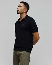 Black MENS DEVON KNIT POLO featuring a refined textured knit, classic fit, and the signature small embroidered Psycho Bunny skull logo prominently placed on the left chest.