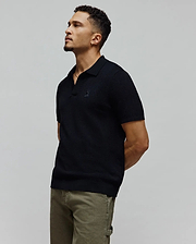 Black MENS DEVON KNIT POLO featuring a refined textured knit, classic fit, and the signature small embroidered Psycho Bunny skull logo prominently placed on the left chest.