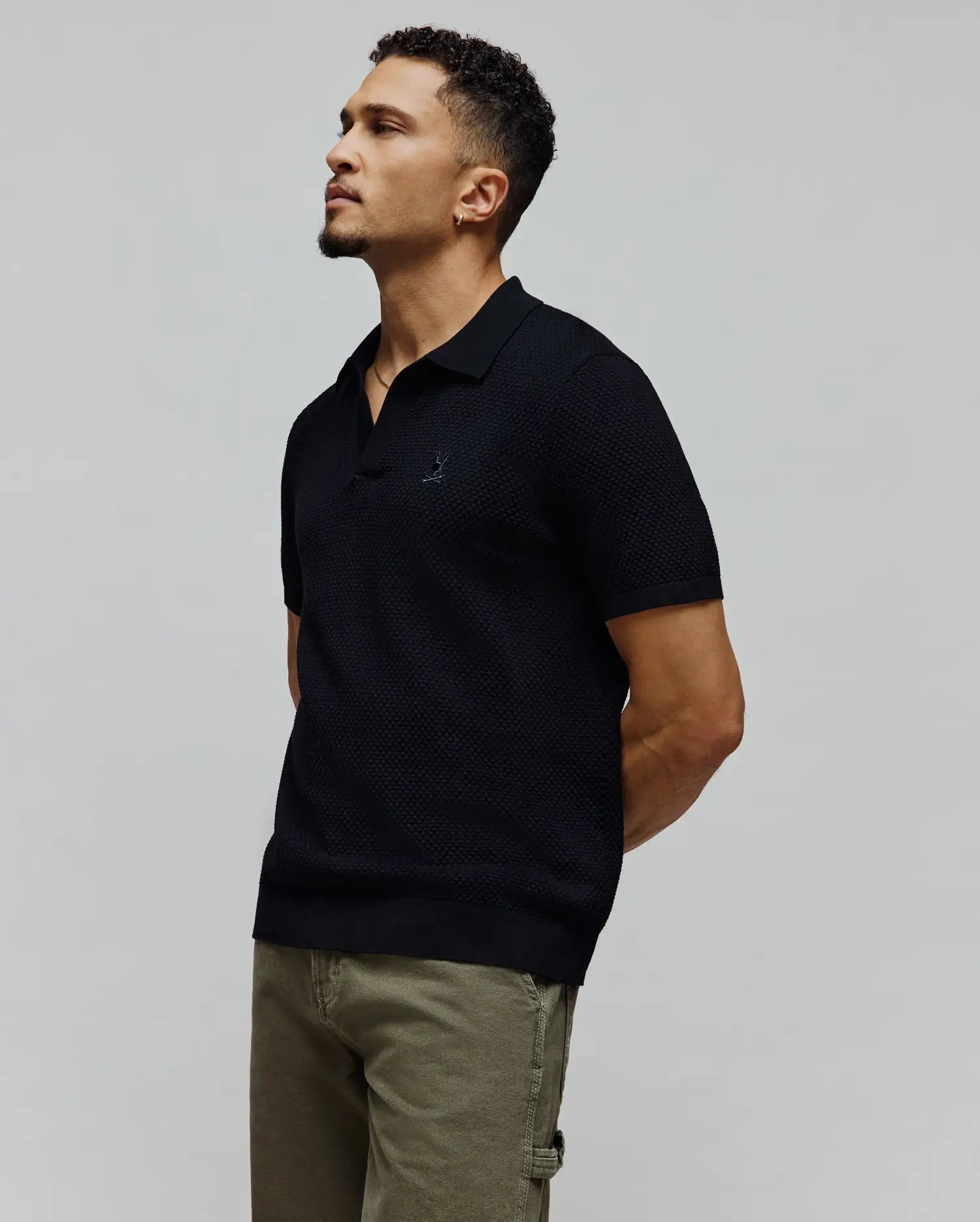 Black MENS DEVON KNIT POLO featuring a refined textured knit, classic fit, and the signature small embroidered Psycho Bunny skull logo prominently placed on the left chest.