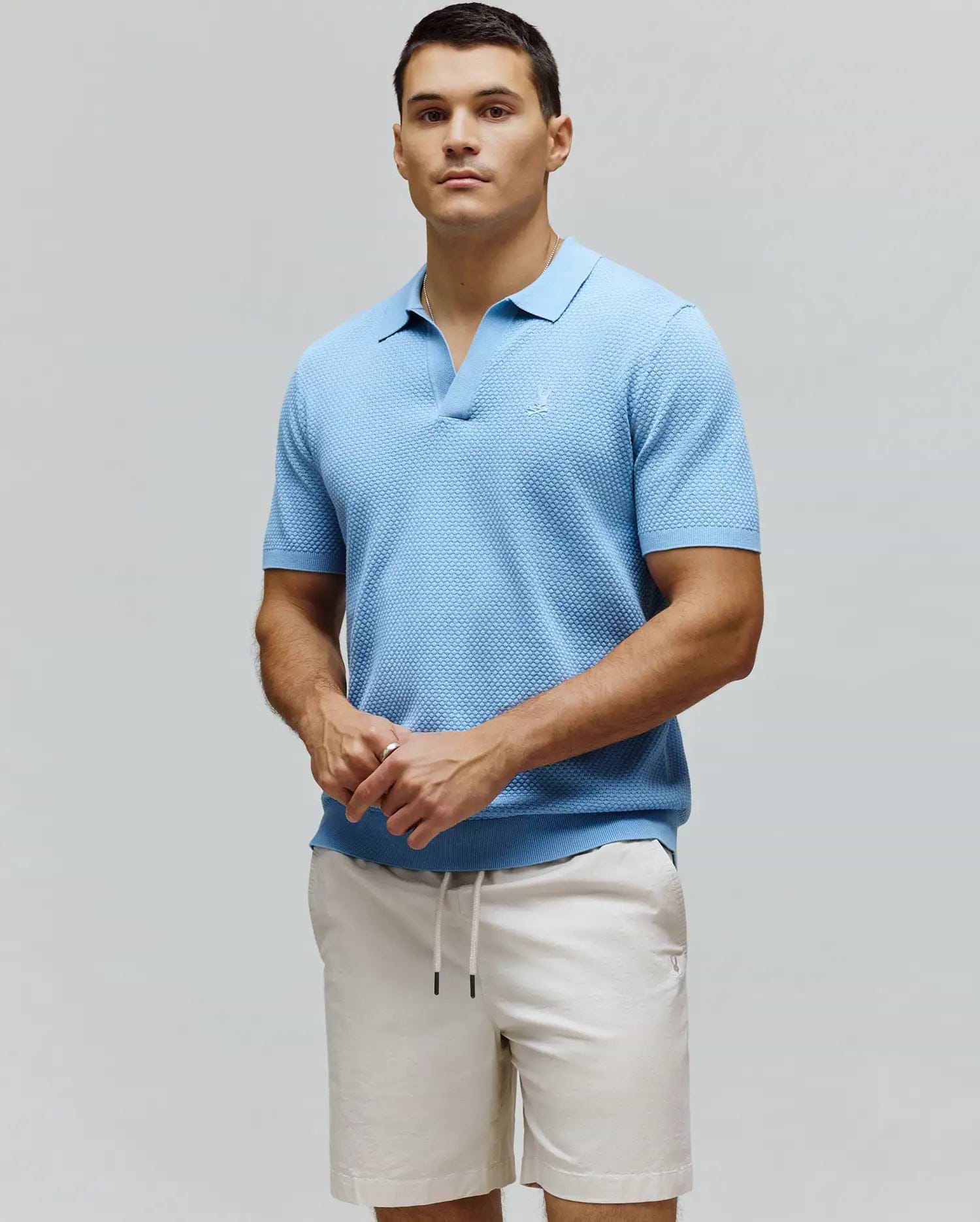 Mens Devon Knit Polo, light blue textured knit polo with an open collar, classic fit, and subtle embroidered Psycho Bunny skull logo on the left chest.