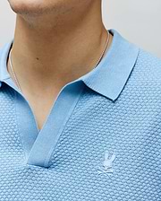 Mens Devon Knit Polo in light blue, featuring a textured knit fabric, ribbed collar, V-neck placket, and a small white embroidered Psycho Bunny skull logo on the left chest.
