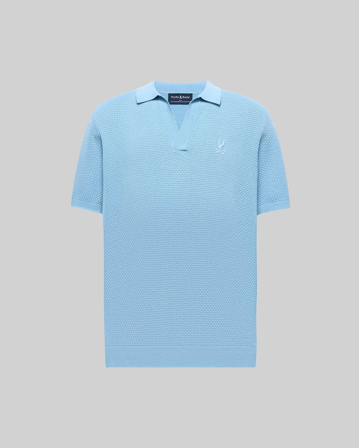 Mens Devon Knit Polo in light blue, featuring a textured knit fabric, open V-neck collar, ribbed cuffs and hem, and a small embroidered Psycho Bunny skull logo on the left chest.